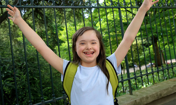 Photo of a girl with her hands in the air.